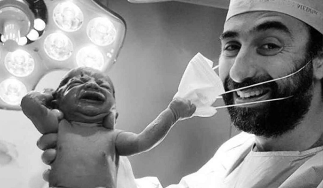 Un semn divin ca omenirea va invinge? Fotografia in care un nou-nascut smulge masca medicului face inconjurul lumii